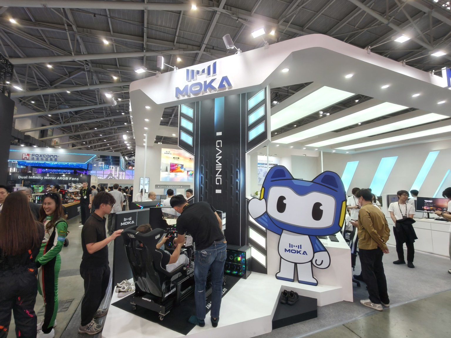 COMPUTEX 2026 展位設計：MOKA 白色斜切量體與藍色吉祥物賽車模擬器