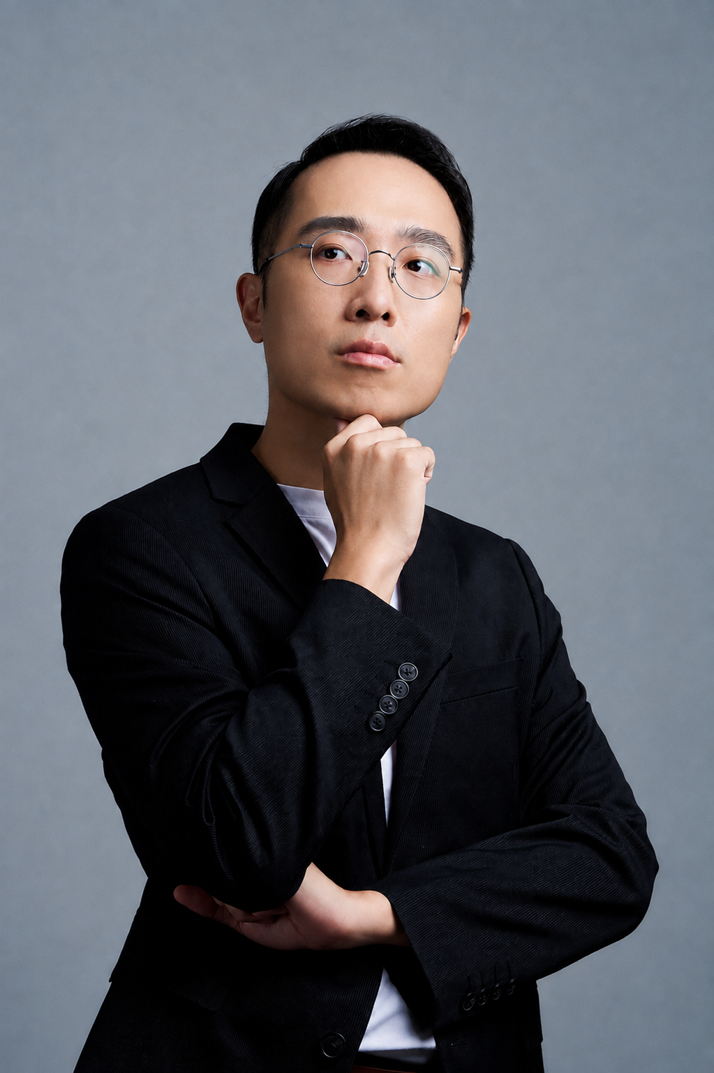 Hans Lin, AI director and educator at Group.G, wearing a black suit